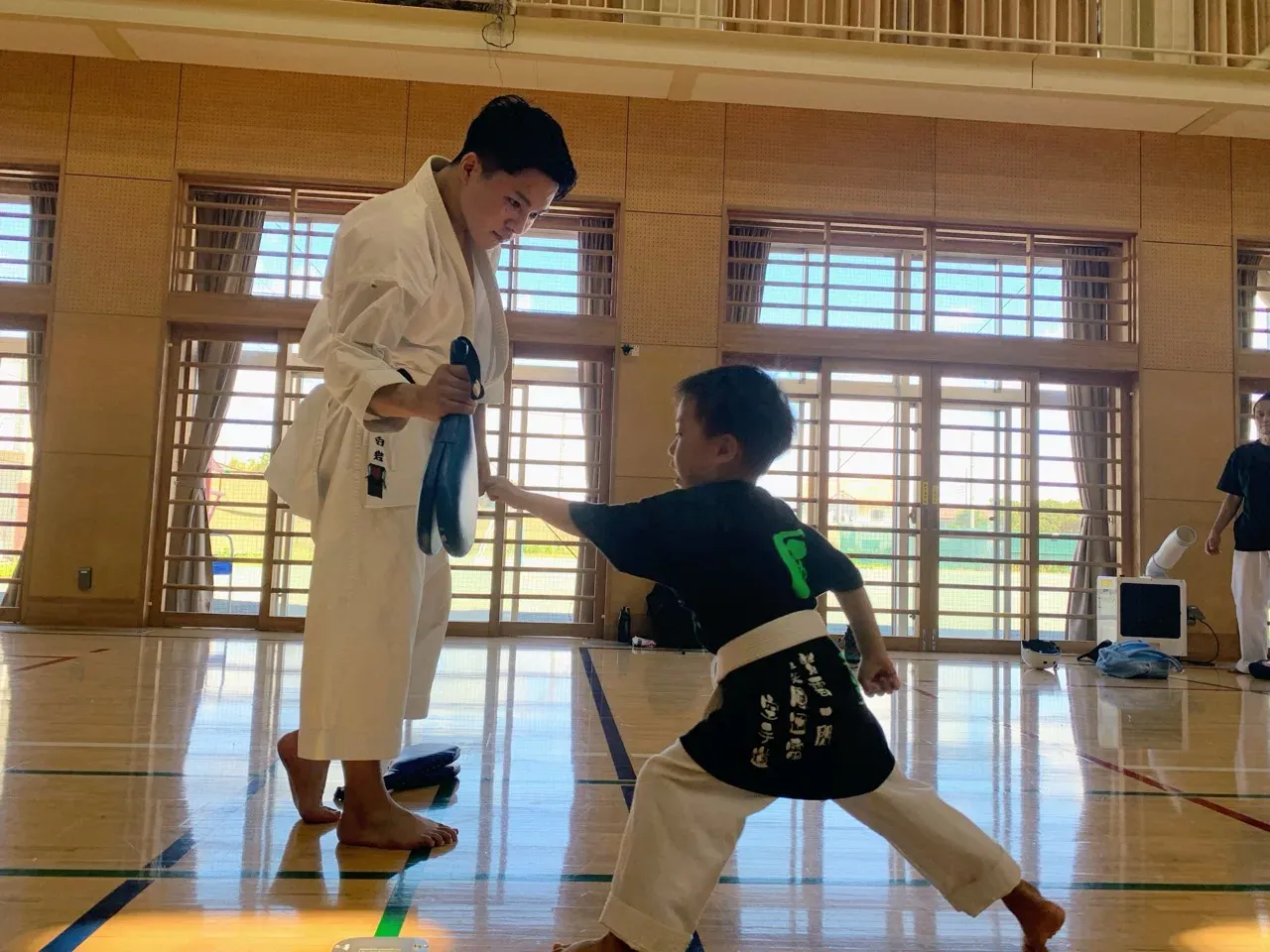空手教室でミット打ちに取り組む子どもと指導者